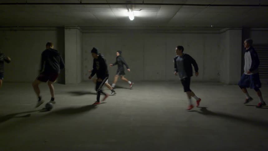 Kids are playing soccer in the parking garage