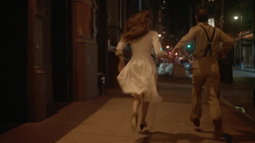 A man and woman running down a city street