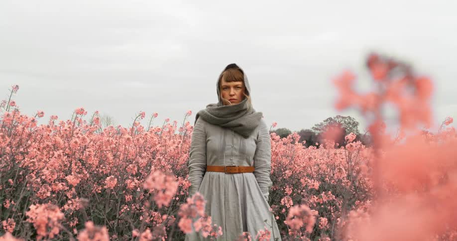 A teenager stands in a field of flowers