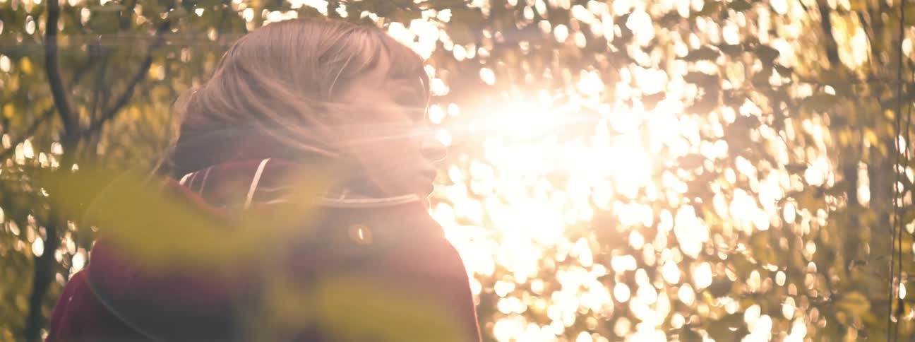 A woman is standing outdoors at dusk