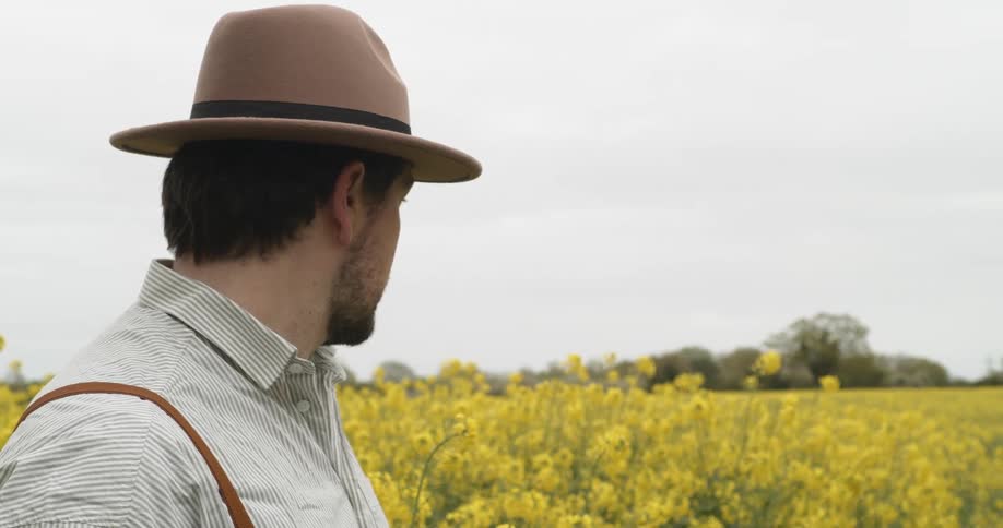 A man stands and looks at a field of flowers