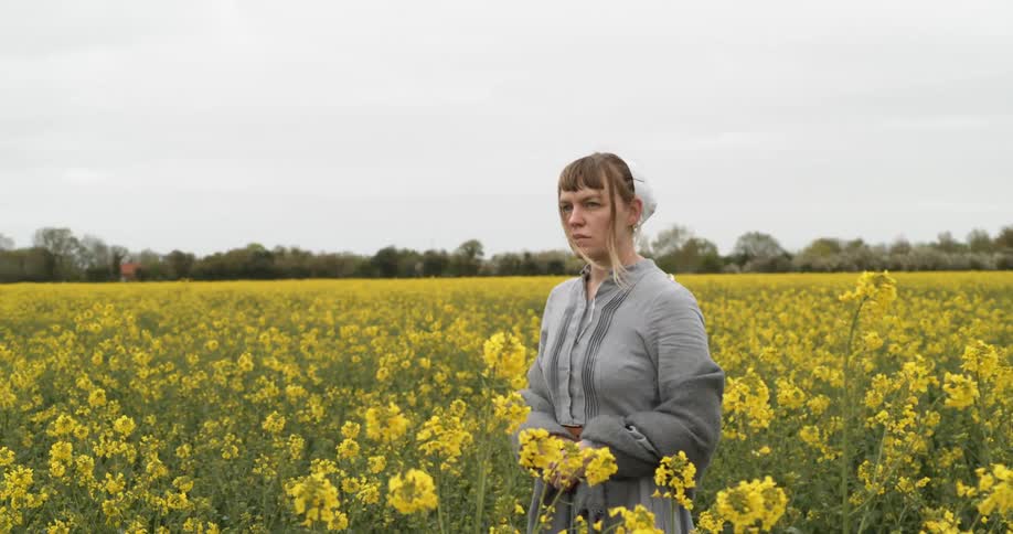 Woman posing in a field of yellow flowers in the country
