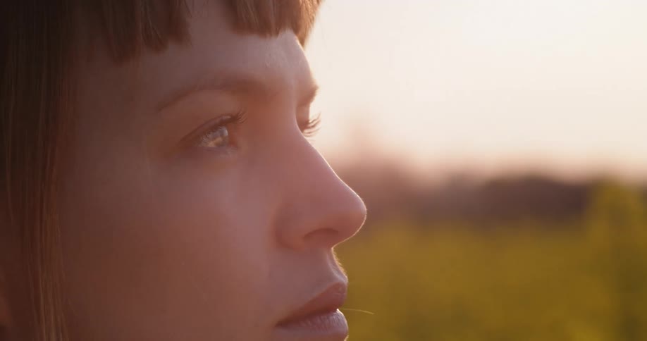 A woman blinks as she looks over the field