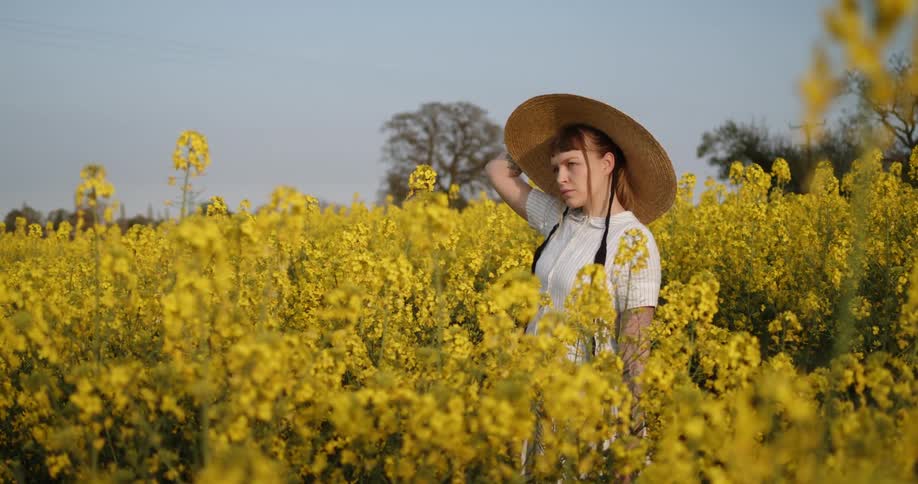 A young woman stands in a field of flowers