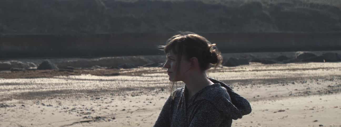 A woman turns to the side on a windy day