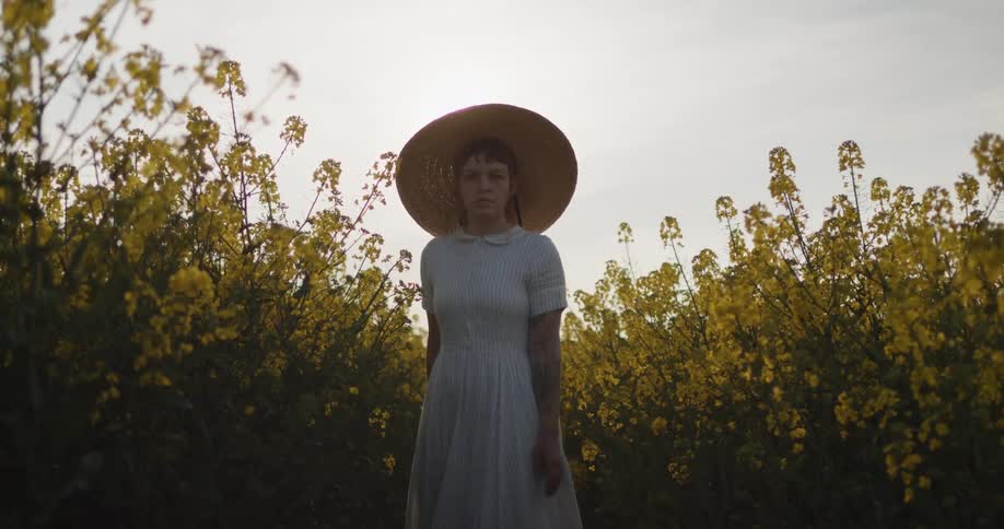 A woman is walking through a flower meadow