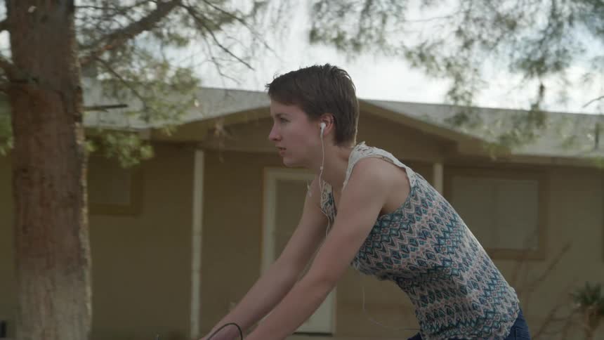 A teenager bikes down a neighborhood street