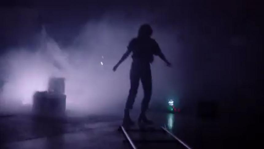 The silhouette ofa woman dancing and twirling while laser lights flash