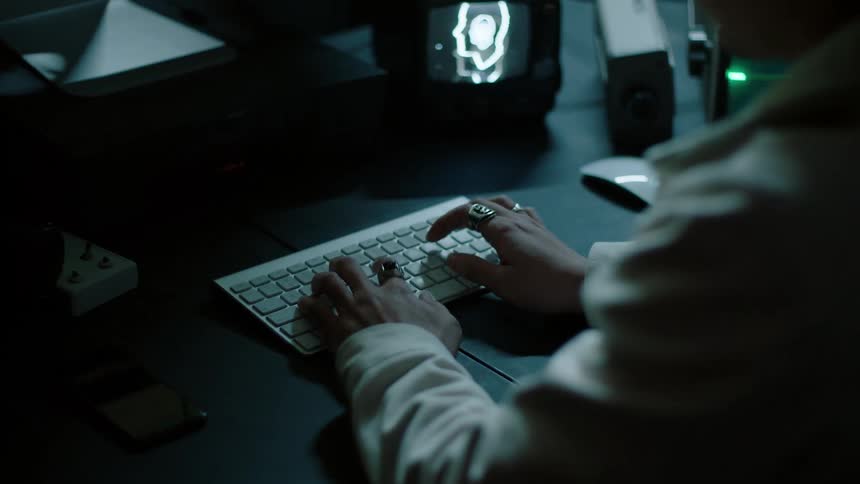 A man sitting at a desk typing on a keyboard in front of a computer