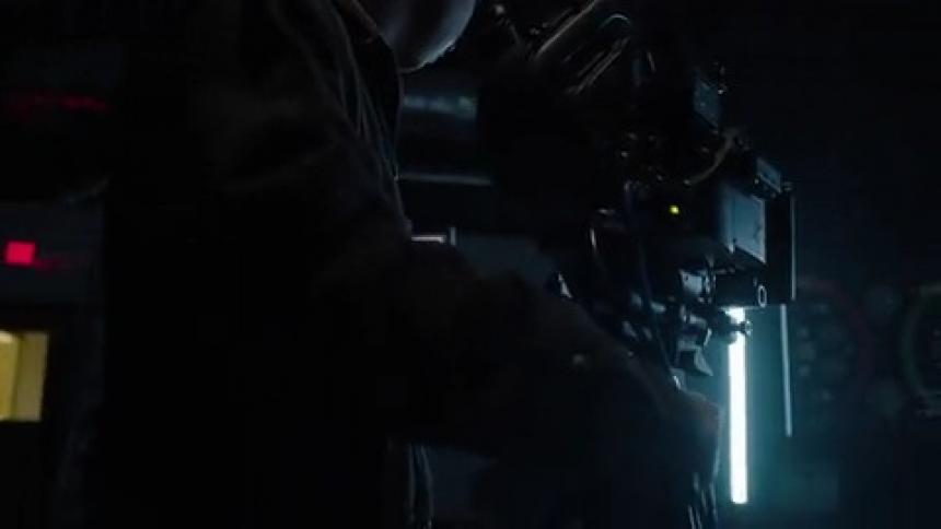 A man is filming in a pitch black studio