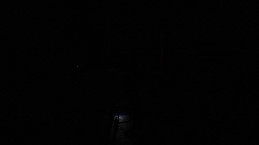 Lights flash quickly on a white man standing behind a movie camera