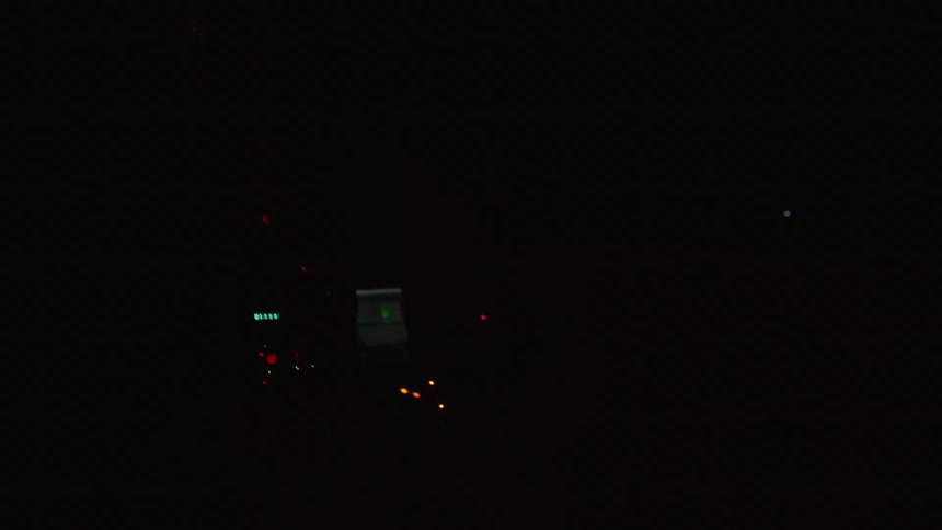 A man adjusts audio equipment as red lights flash
