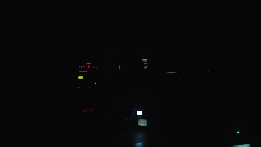 A man works on audio equipment as lights flash brightly