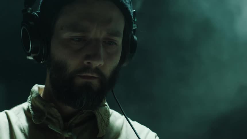 A man with headphones on works on equipment