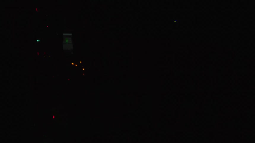 A man dances as he works with audio equipment as lights flash