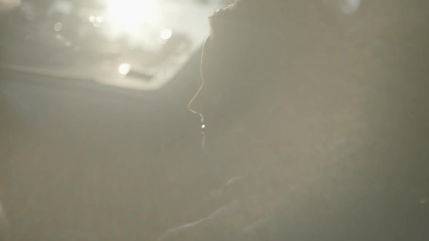 A woman is smiling as she sits in a passenger seat of a moving car