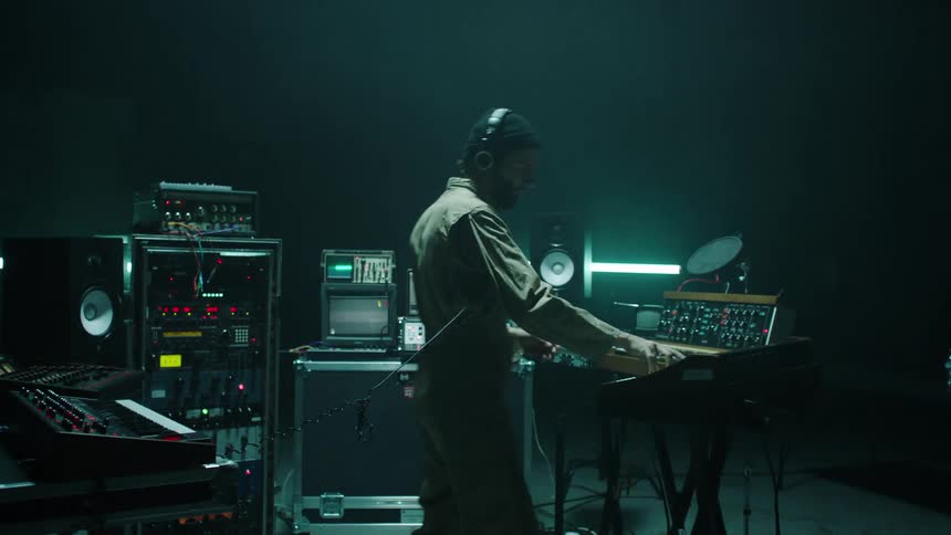 A man in a studio works on audio equipment
