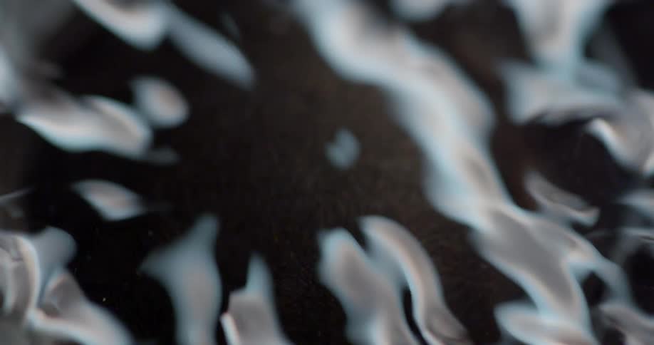 A close view of water rippling within a metal container