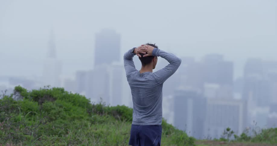 Man looks at city skyline under the mist