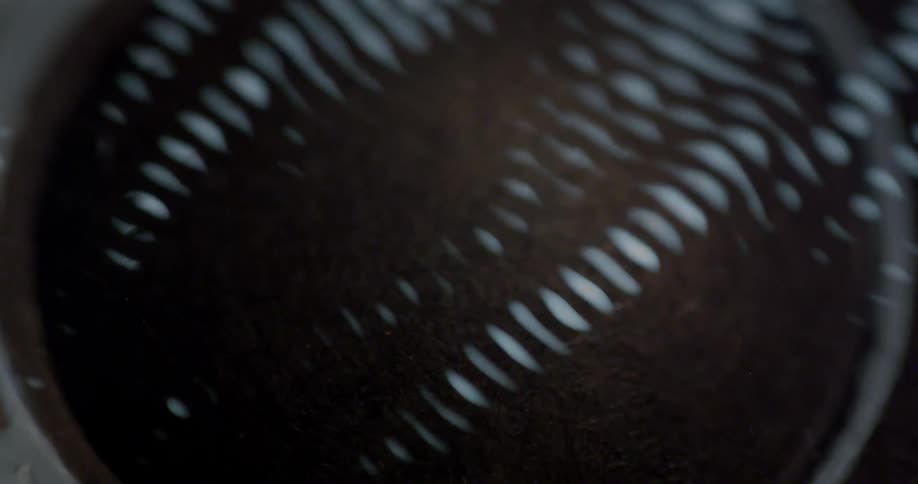 Bands of light appear and fluctuate over a cup with dirt in it
