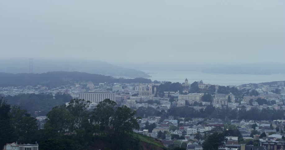 Buildings and homes set amidst rolling hills and trees
