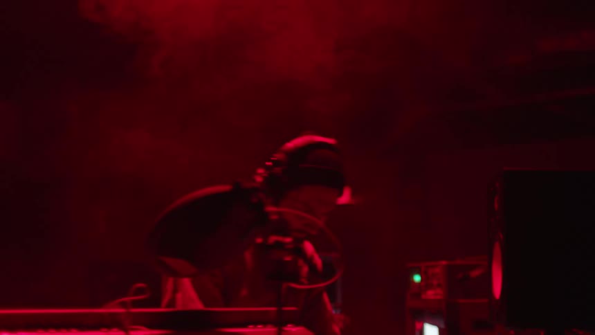 A black musician plays music surrounded by a bank of instruments and machines