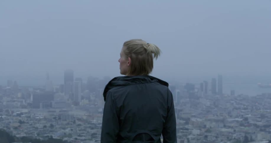A woman is watching a view of a downtown skyline