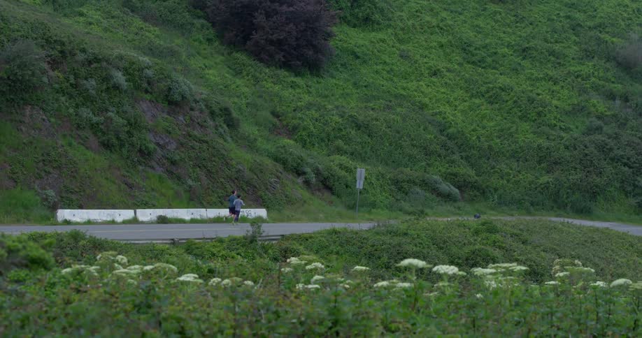 A father runs with his son down a road