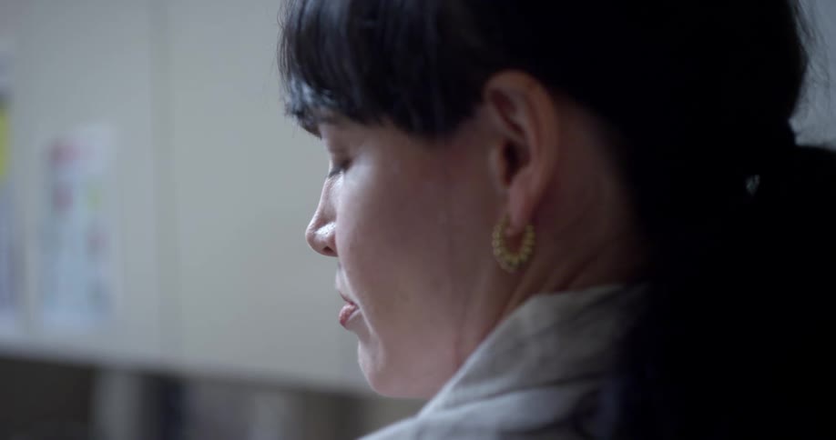 A woman turns to someone and talks