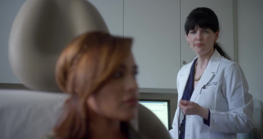 A doctor talking to a woman sitting on a chair