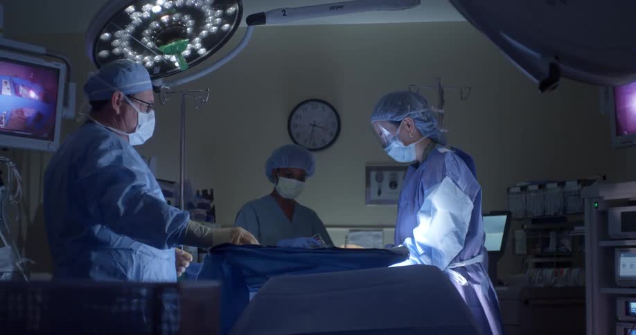 Doctor and two nurses work in an operating room