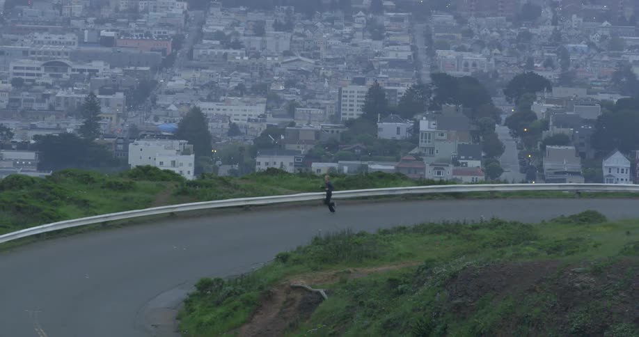 A person running on a road with the city skyline behind them