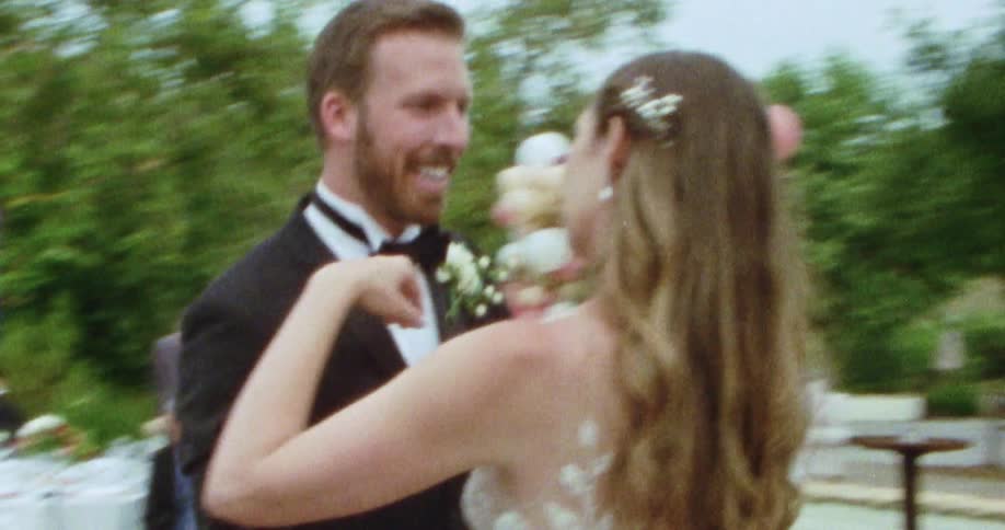 A bride and groom dance at their wedding as guests watch