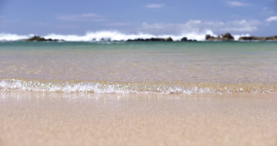 Gentle ocean waves on the sands of a beach