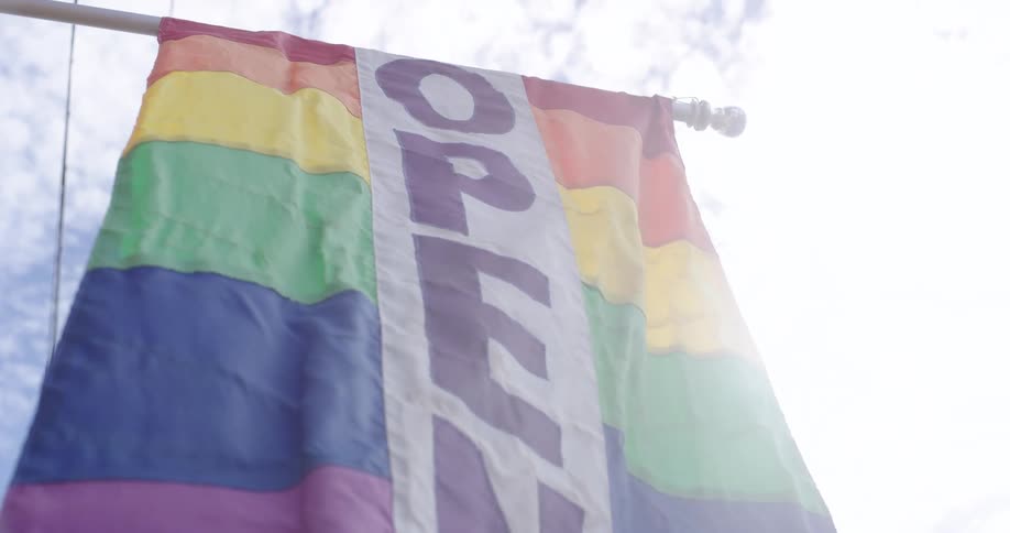 Banner composed of series of rainbow colored sections with the word open hangs