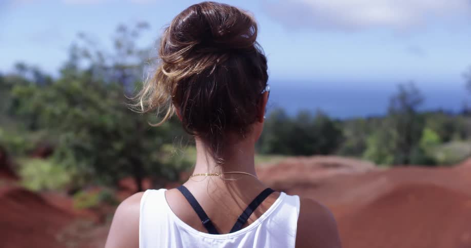A woman is standing outdoors during midday