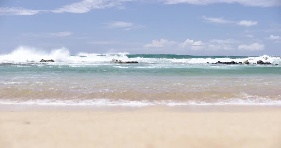 Calm ocean waves on the sands of a beach at day