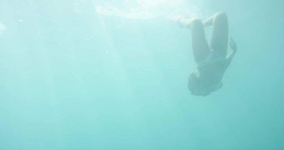 A woman dives underwater with flippers