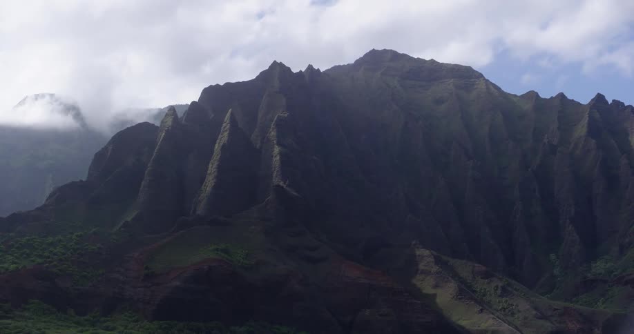 Mountains sit under a cloudy blue sky