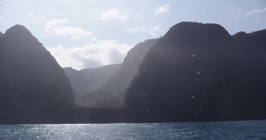 The fog is rolling over the mountains past the water