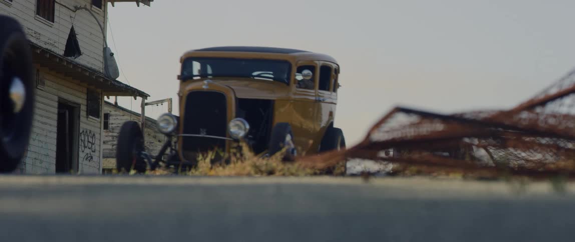 Vintage cars being driven down a street
