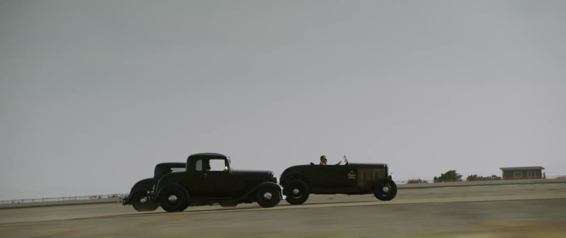 Vintage antique cars racing on a rural road