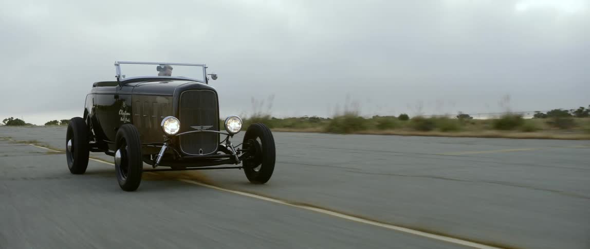 People are racing their vintage cars on a cloudy day