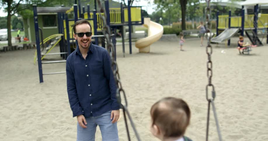 A man kisses his baby each time he swings forwards