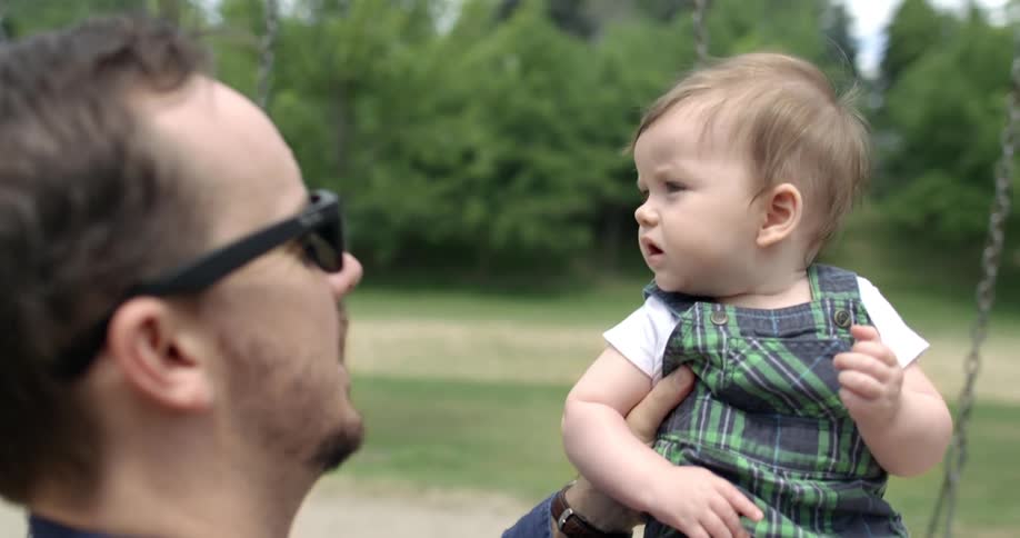 A father holds his son in the playground