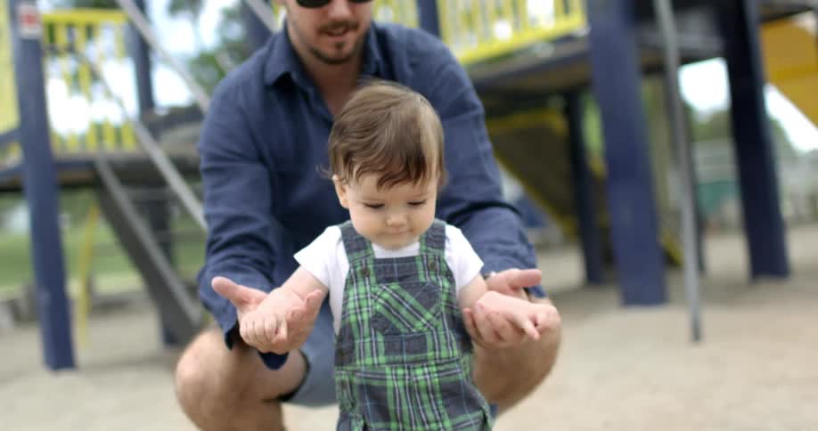 A father and son are playing at the park