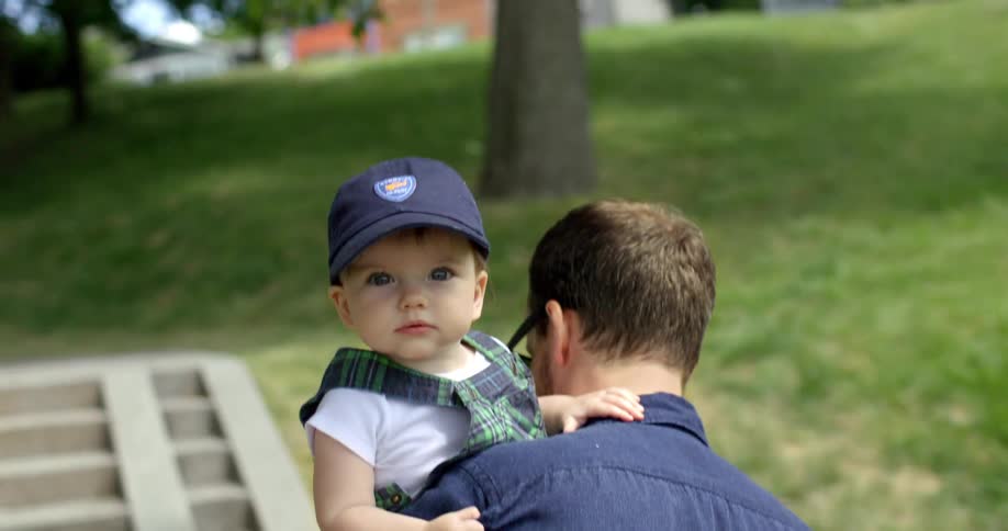 Baby being carried by dad while walking up steps at a park