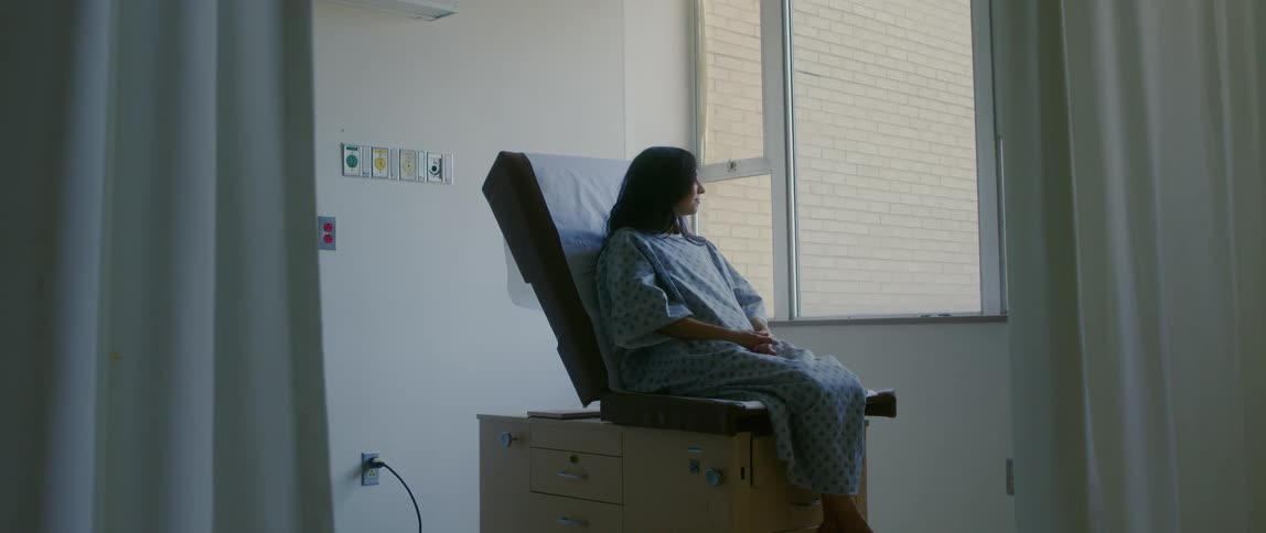 Female patient waits sitting on an examination table in a clinic