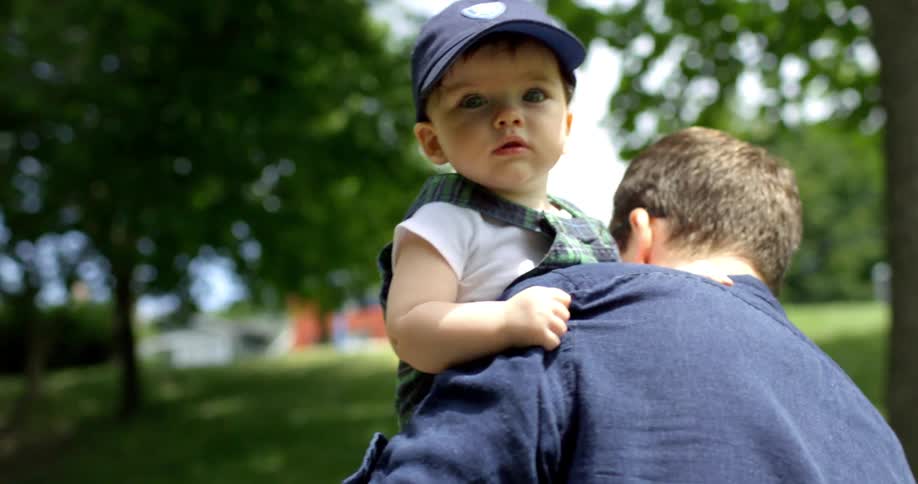 Father carries son through the neighborhood