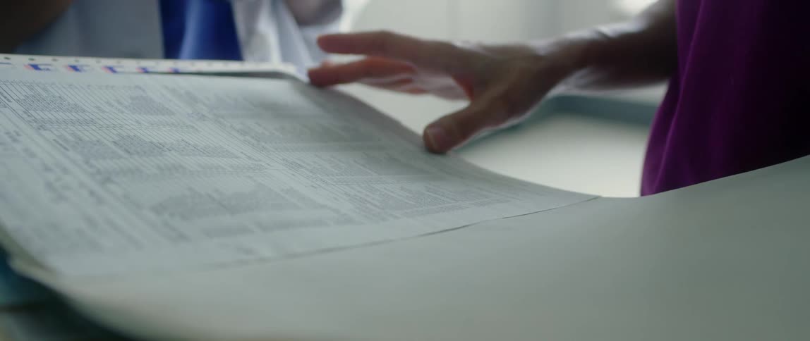 A nurse discusses a patients paperwork with a doctor